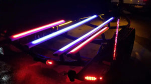 Illuminated boat trailer with red and blue LED light strips along its frame.